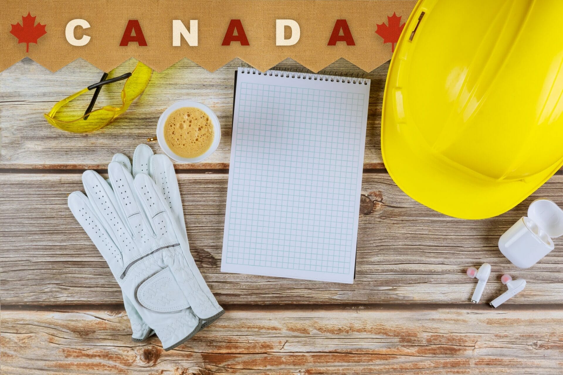 Engineer working on office desk with blank notebook construction protective yellow safety helmet on Canada happy Labor Day is a holiday