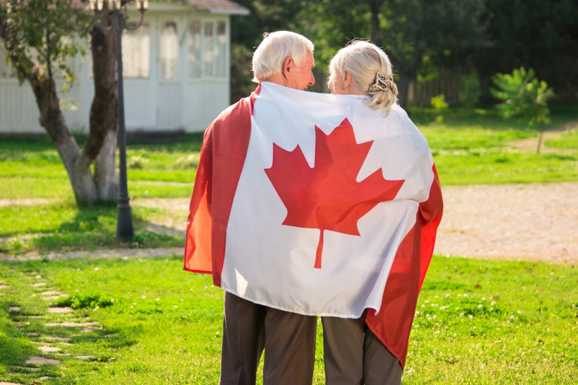 Senior couple and Canadian flag. Two elderly people, back view. Love to homeland.
